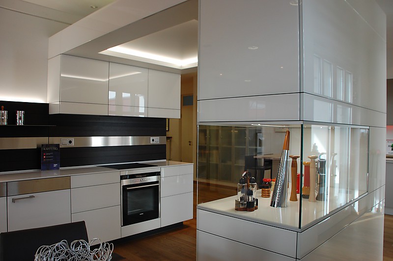 Moderne Ausstellungsküche mit weißen Glafronten und Glasvitrine im Hochschrank